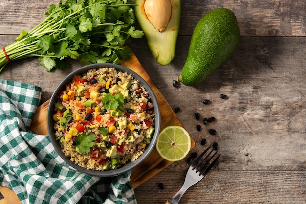 Ensalada mexicana con quinua en un tazón sobre mesa de madera.