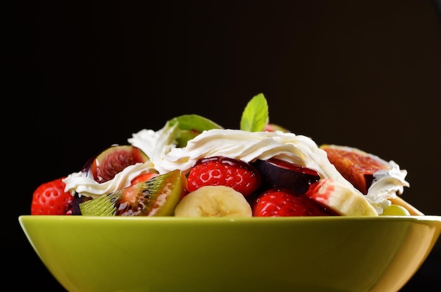 Ensalada de mezcla de frutas saludables sobre fondo oscuro