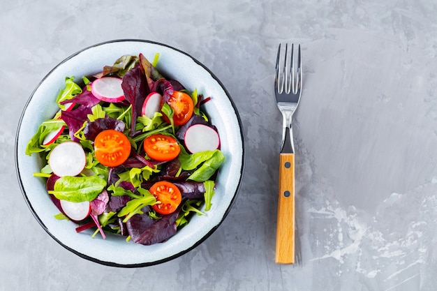 Ensalada con mezcla de verduras sobre fondo gris