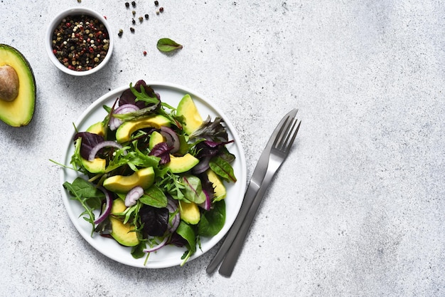 Ensalada mixta con aguacate y salsa sobre un fondo de hormigón