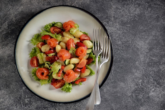 Ensalada de ñoquis de papa con tomate, pepino, pimiento morrón, salmón y lechuga