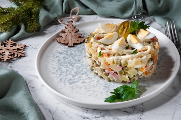 Ensalada Olivier en un plato sobre la mesa Sirviendo en la mesa