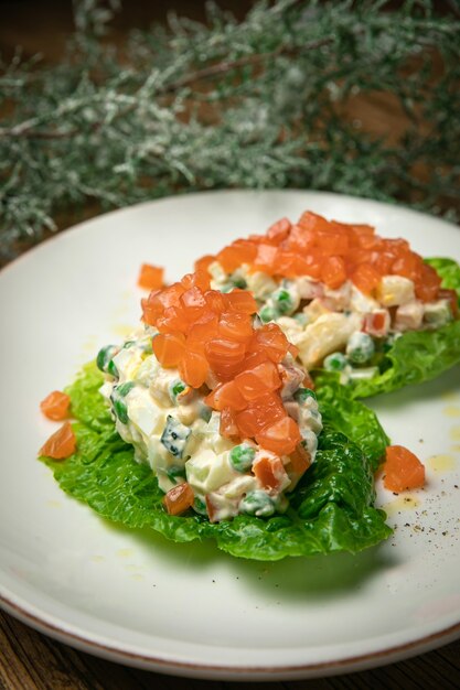 Ensalada Olivier con salmón en una mesa de madera