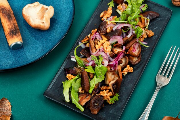 Ensalada de otoño con hongos estofados cebollas lechuga y nueces Concepto de comida saludable