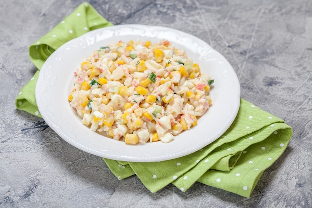 Ensalada con palitos de cangrejo, maíz, pepino y huevos