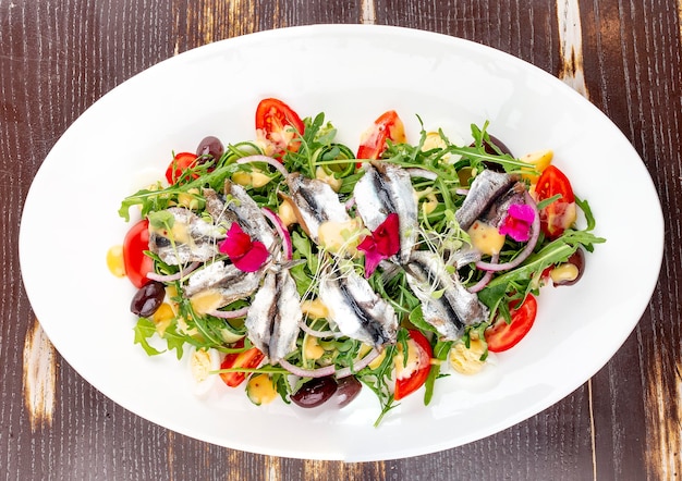 Ensalada con papas hervidas espadín huevo pepinos y rúcula