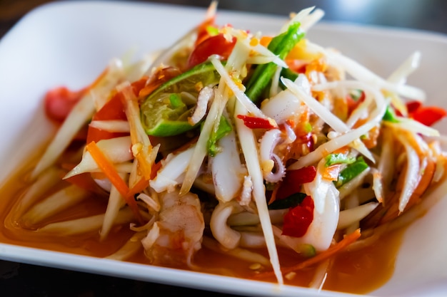 La ensalada de papaya con camarones y pulpo, comida tradicional tailandesa picante.