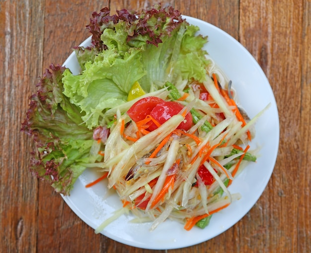 Ensalada de papaya con cangrejo en la mesa de madera