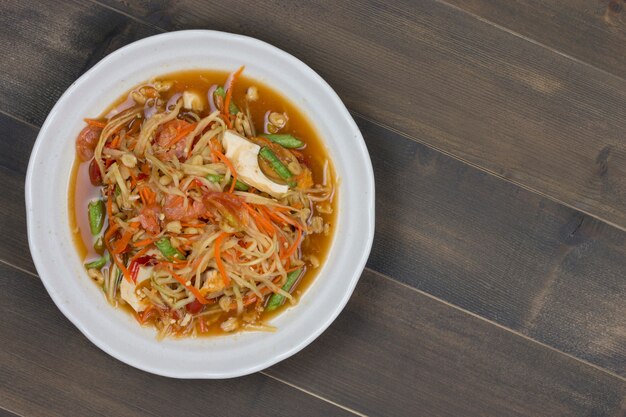 Ensalada de papaya picante tailandesa en mesa de madera