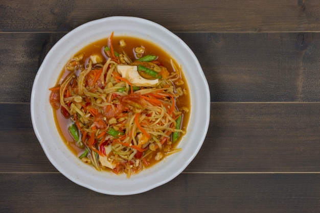 Ensalada de papaya picante tailandesa en mesa de madera