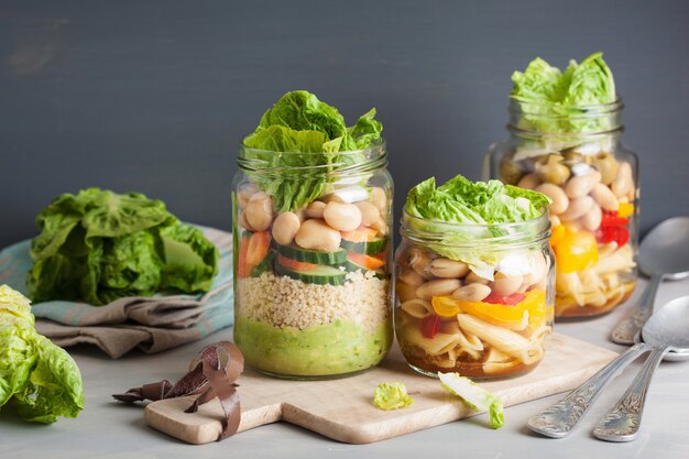 Ensalada de pasta y cuscús vegano en tarros de albañil con frijoles vegetales