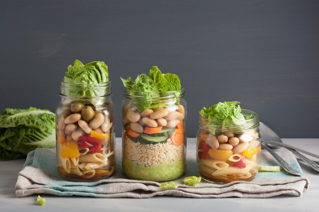 Ensalada de pasta y cuscús vegano en tarros de albañil con frijoles vegetales