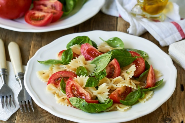 Ensalada de pasta farfalle con tomate y albahaca verde