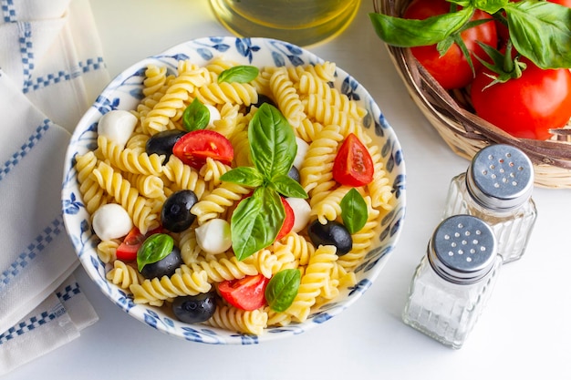 Ensalada de pasta fría italiana o Pasta fredda alla caprese. Directamente arriba. Fusilli, tomate, mozzarella, aceituna, rúcula. nombre turco; burgu makarna salatasi