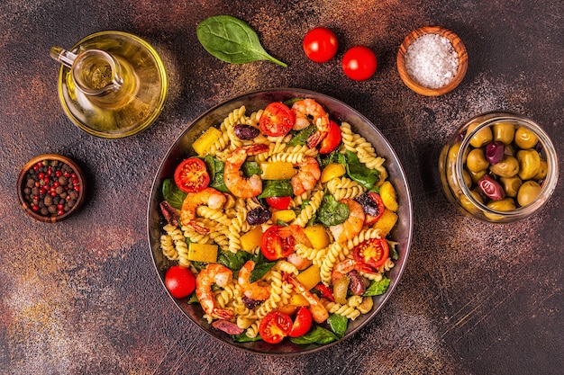 Ensalada de pasta fusili con gambas, tomates, pimientos, espinacas, aceitunas