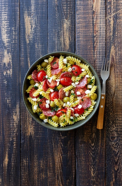 Ensalada con pasta fusilli salchicha aceitunas y requesón comida italiana