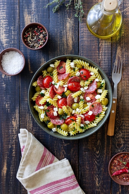 Ensalada con pasta fusilli salchicha aceitunas y requesón comida italiana