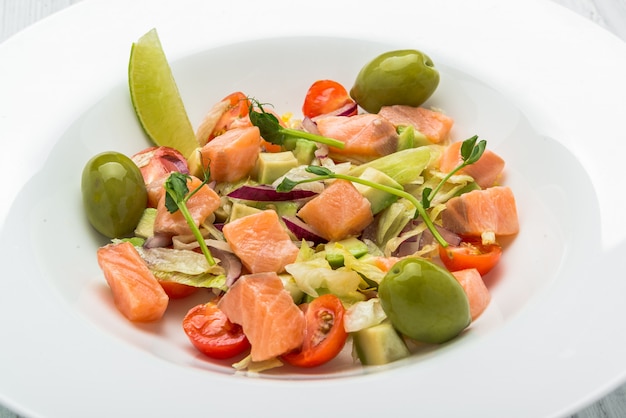 Ensalada de pasta con salmón ahumado, aceitunas, tomates cherry, pimienta rosa y albahaca fresca