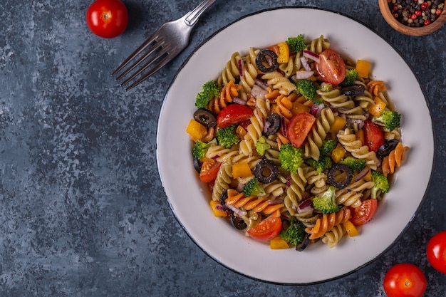 Ensalada de pasta con tomate, brócoli, aceitunas negras. Vista superior