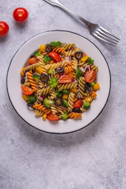 Ensalada de pasta con tomate, brócoli, aceitunas negras. Vista superior