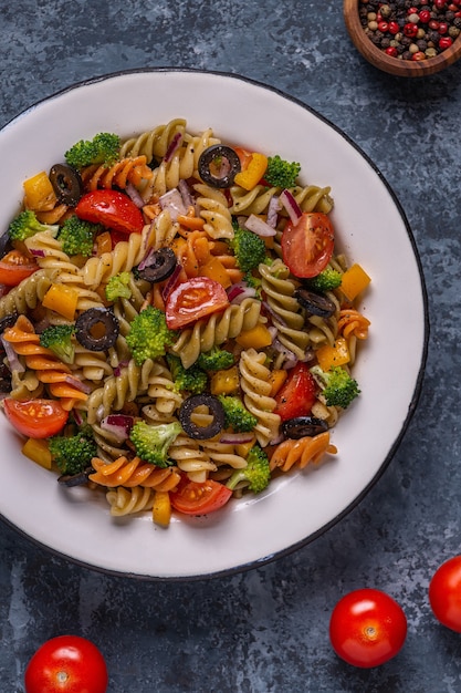 Ensalada de pasta con tomate, brócoli, aceitunas negras. Vista superior