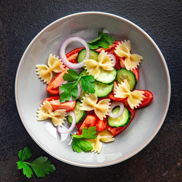 Ensalada de pasta, verduras y farfalle, comida saludable, bocadillo en la mesa, espacio de copia, fondo de alimentos