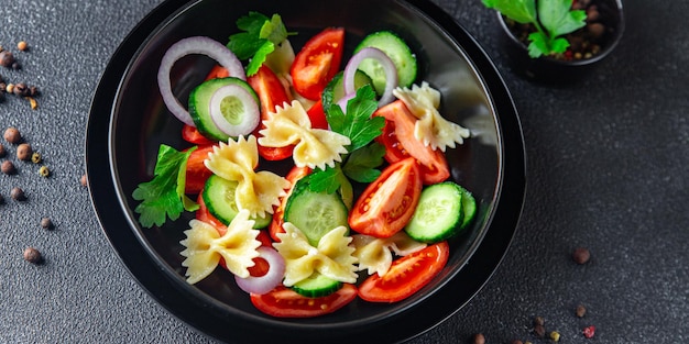 Ensalada de pasta, verduras y farfalle, comida saludable, bocadillo en la mesa, espacio de copia, fondo de alimentos