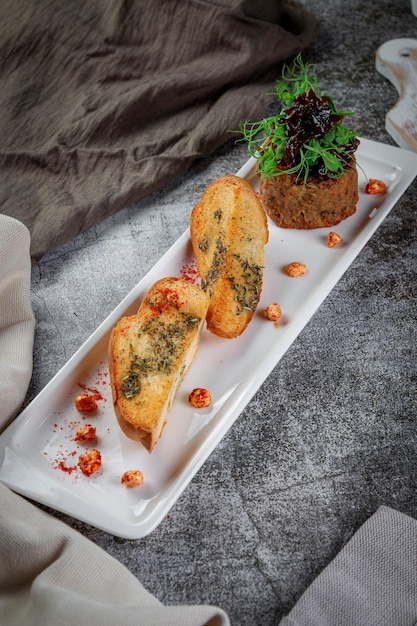 Ensalada con paté de hígado de ciruelas y guisantes y picatostes fritos