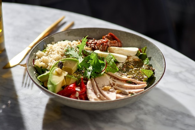 Ensalada de pechuga de pollo, cuscús, hummus, aguacate y mozzarella