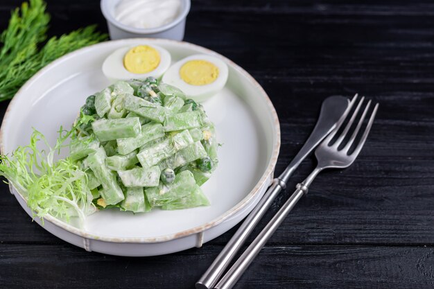 Ensalada de pepinos frescos, hojas de espinaca, rúcula, aguacate. Servido con rodajas de huevo y pimiento rojo.