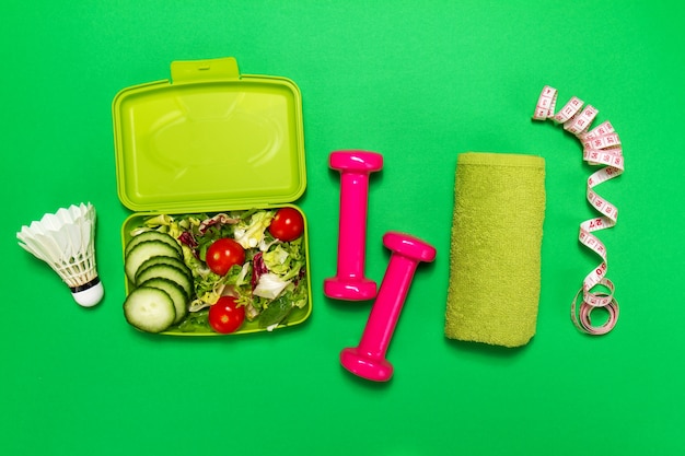 Foto ensalada con pesas y una pelota de badminton