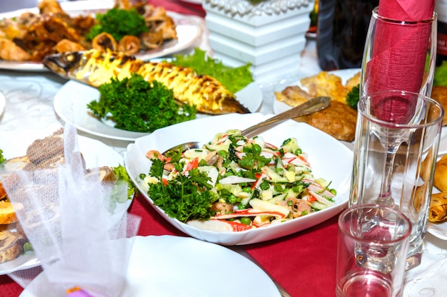 Ensalada, pescado y otros platos en la mesa del banquete.