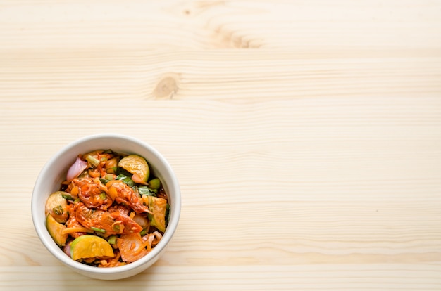 Ensalada picante de los mejillones conservados en vinagre en la tabla de madera, comida tailandesa.