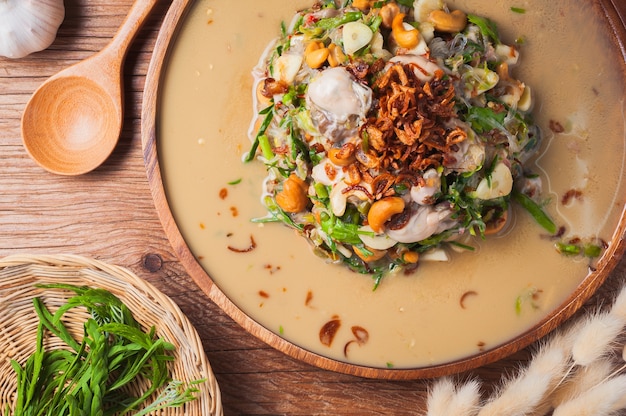 Ensalada picante de la ostra fresca de los tallarines de cristal en la tabla de madera.