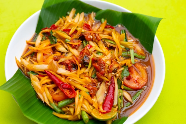 Ensalada picante de papaya con conchas en escabeche