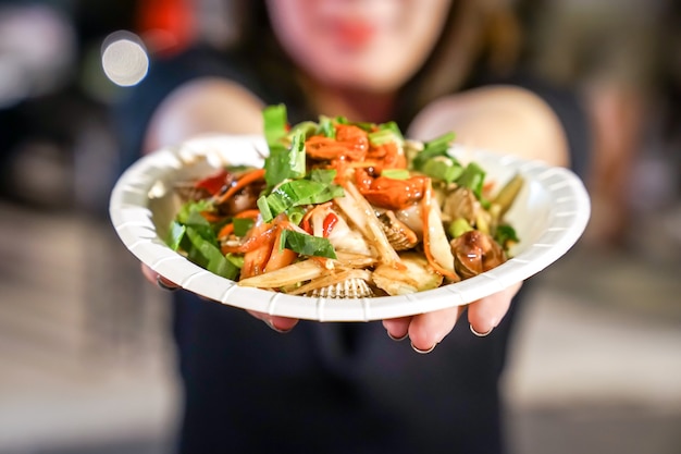 Ensalada picante tailandesa de tres conchas en el evento foodtruck.