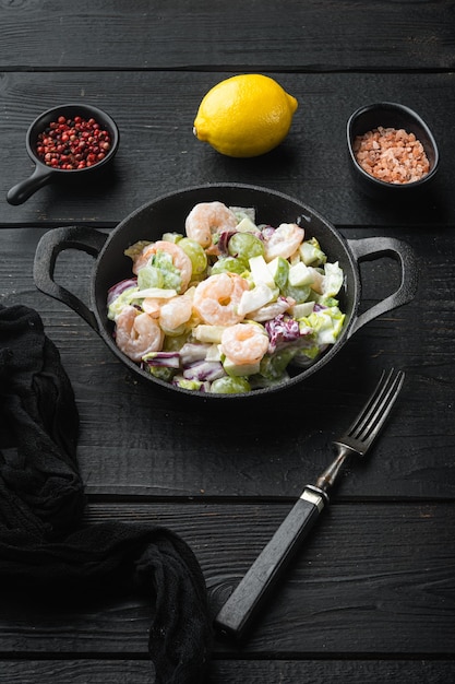 Ensalada de picnic orgánico de frutas frescas y nueces: apio, mariscos frescos, con salsa de manzana y uva, sobre mesa de madera negra