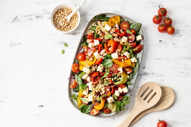 Foto ensalada de pimienta asada y frijol de mantequilla con aderezo de harissa sobre fondo blanco