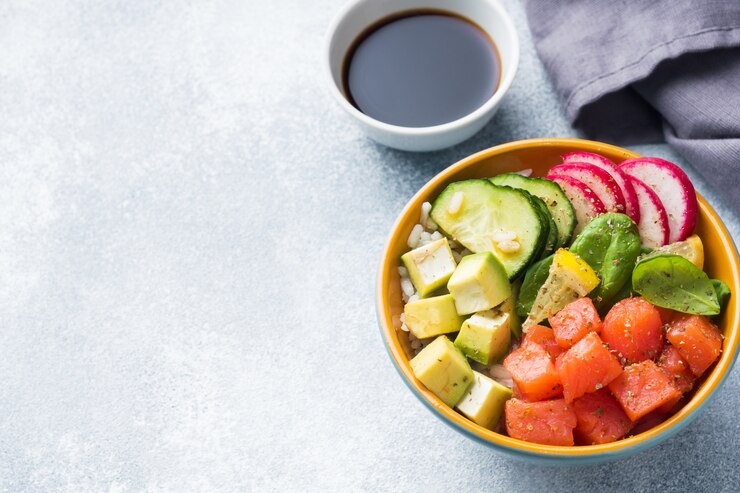 Ensalada Poke hawaiana tradicional con salmón, arroz con aguacate y verduras en un tazón
