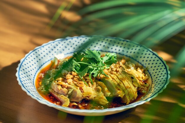 Ensalada de pollo hervido, cilantro, maní en salsa de soja picante. Cocina china.