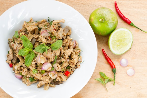 Ensalada de pollo picada picante en la mesa de madera