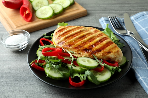 Ensalada de pollo a la plancha sobre mesa gris