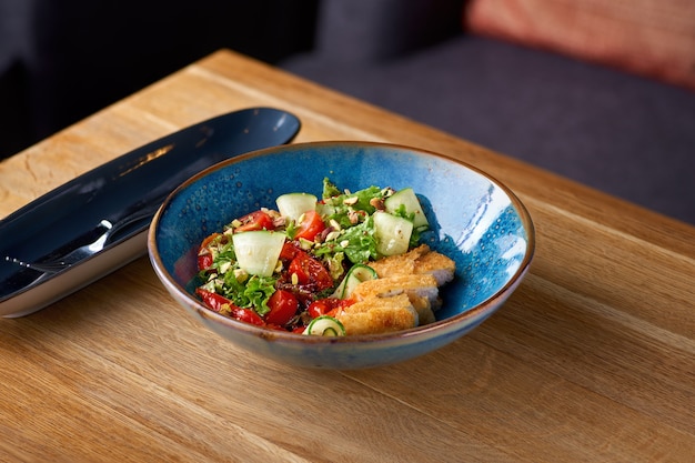 Ensalada de pollo con tomate y pepino en la mesa