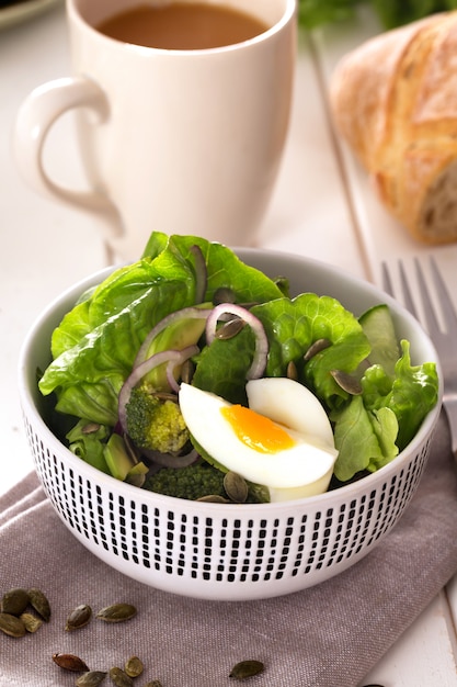 Ensalada preparada con hojas verdes frescas, cebolla y huevo de gallina hervido