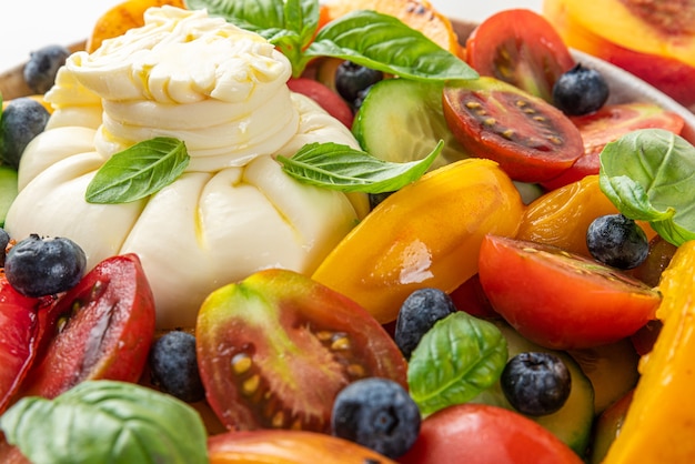 Ensalada de queso burrata con duraznos a la plancha tomates arándanos pepino y albahaca