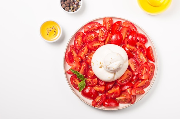 Ensalada de queso burrata con tomates, aceite de oliva y condimentos. Concepto de comida fresca.