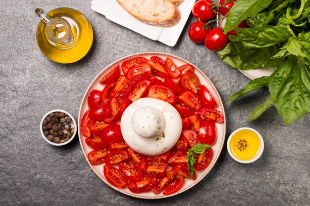 Ensalada de queso burrata con tomates cherry, aceite de oliva y aliño. Concepto de comida fresca.