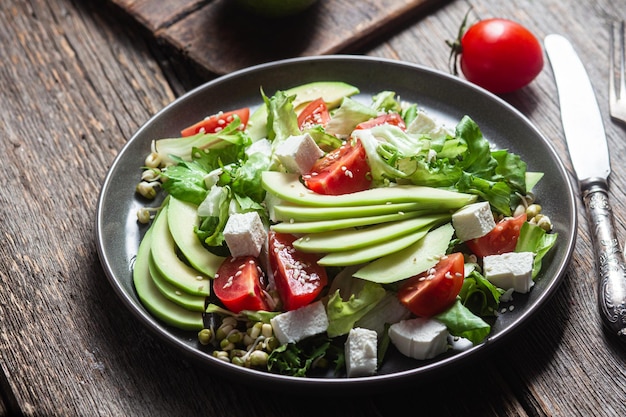 Ensalada con queso feta aguacate y tomates en un bol