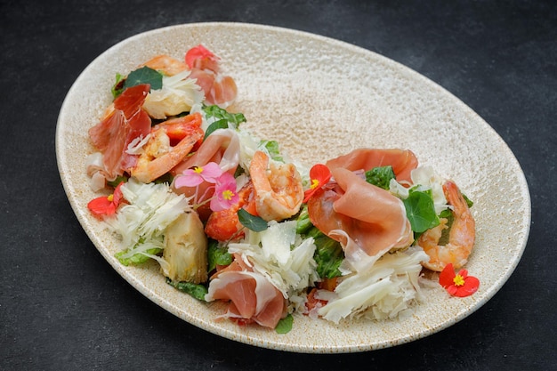 Ensalada con queso de gambas y prosciutto en un plato