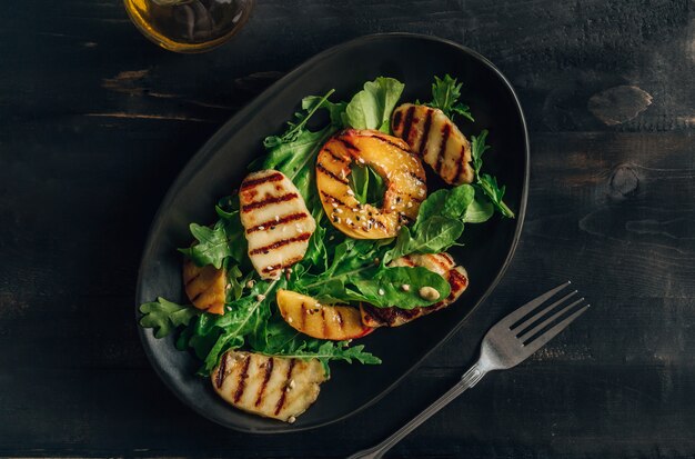 Ensalada de queso Halloumi a la plancha con melocotón y rúcula.